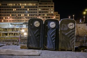 Nowoczesne toalety przenośne ToiToi zainstalowane na terenie obiektu publicznego ze wsparciem infrastruktury sanitarnej